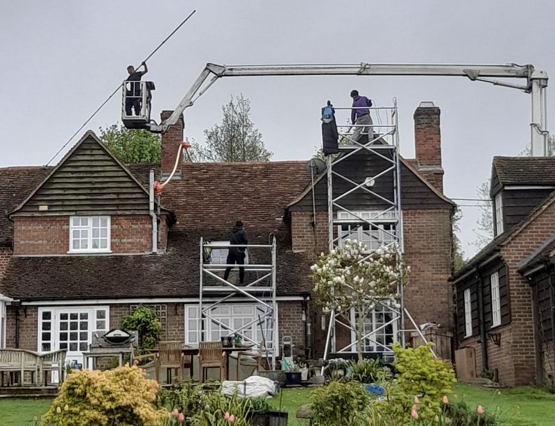 The Moss Cleaners using cherry picker and scaffolding to clean roof safely and professionally in Tadley, Hampshire